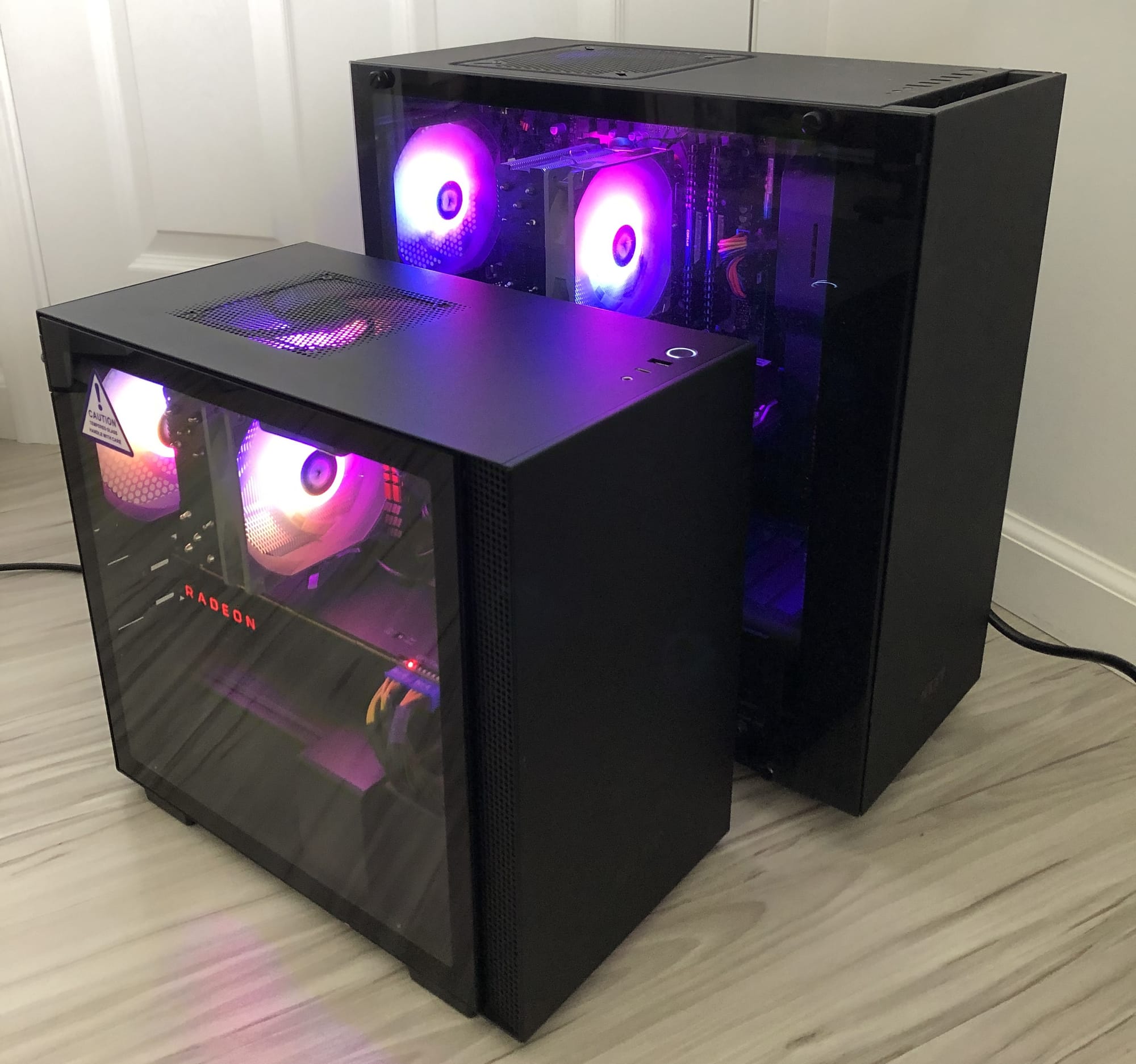 A black NZXT H210 ITX PC case next to a black NZXT S340 ATX PC case